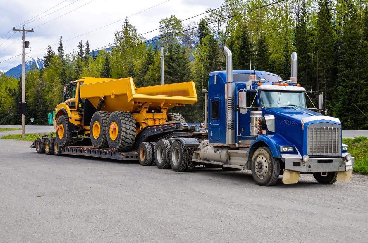 Excavator being driven onto an RGN trailer